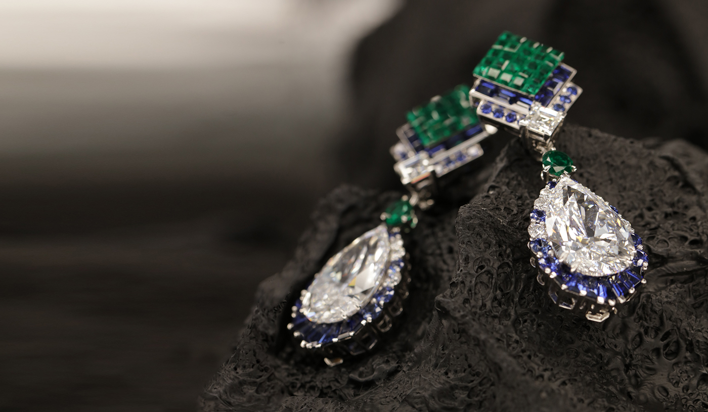 Mas Tassini studio photo, Van Cleef and Arpels haute joaillerie,CHEVRON MYSTÉRIEUX EARRINGS WITH DETACHABLE PENDANTS White gold, rose gold, three DFL Type 2A pear-cut diamonds of 31.24, 12.18, and 12.07 carats, one DFL Type 2A round diamond of 1.08 carats, Traditional Mystery Set emeralds, emeralds, sapphires, diamonds.