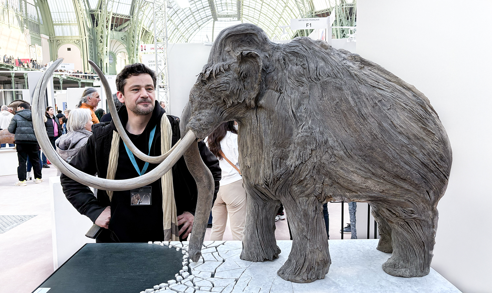 ANGE, at the salon des artistes français, Art Capital 2025 behind his awarded sculpture, the edge mag